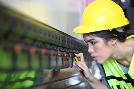 Woman engineer control lathe machine to drill components. Metal lathe industrial manufacturing...