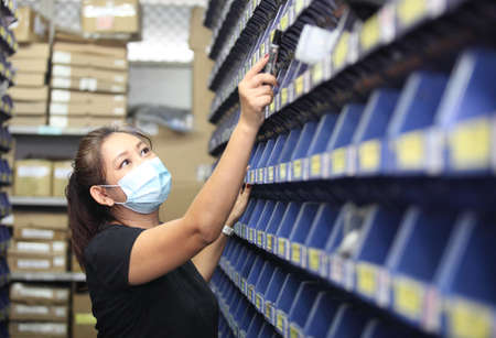worker in warehouse,  using bar code scanner to scanning box and analyze newly arrived goods.  Working at warehouse.International export business conceptの写真素材