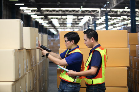 Portrait of worker in warehouse , they  happy and  working at The Warehouse. Storehouse area, Shipment.  warehouse worker unloading pallet goods in warehouseの写真素材