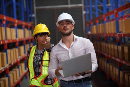worker in warehouse,  using bar code scanner to scanning box and analyze newly arrived goods. ...