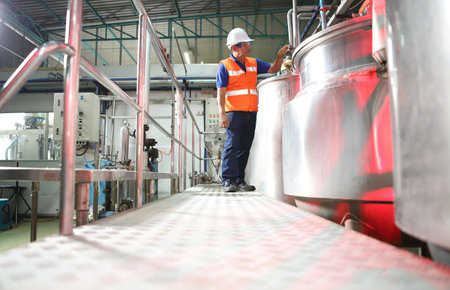 Factory worker inspecting production line of drink production in factory , Concept of food industryの写真素材