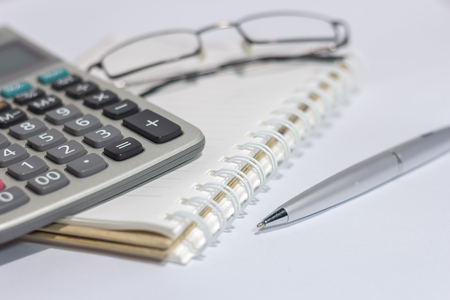 eyeglasses and Calculator on bookの写真素材