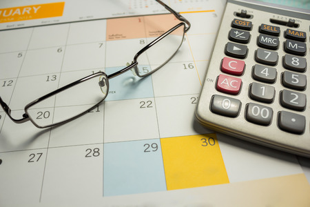 Business concept with calendar and Calculator and eyeglassesの写真素材