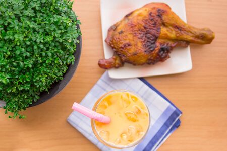 Cold tea in a glass with grilled chicken, cooked hot meal with beautifully laid.の写真素材