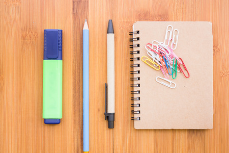 Pens, pencils and notebooks arranged on a wooden table with vintage style.の写真素材