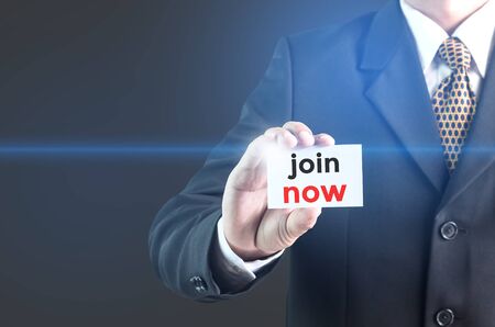 A Businessman holding a white sign with the message join now. Can bring to the medium of your ad.の写真素材