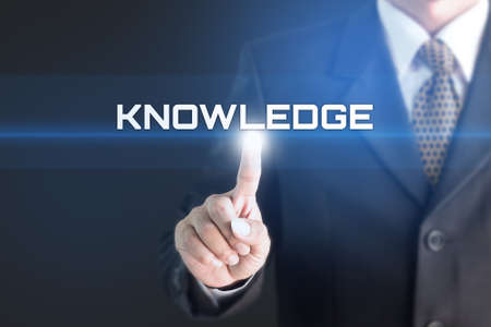A Businessman holding a white sign with the message KNOWLEDGE. Can bring to the medium of your ad.の写真素材