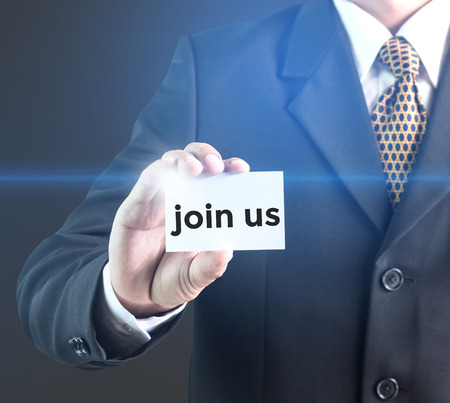 A Businessman holding a white sign with the message Join us. Can bring to the medium of your ad.の写真素材