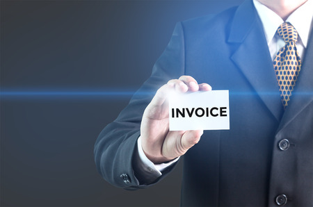 A Businessman holding a white sign with the message Invoice. Can bring to the medium of your ad.の写真素材