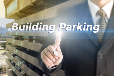 Business man pressing hand Building parking word on virtual screen.の写真素材