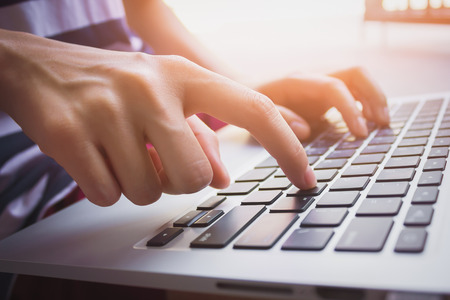 Woman sit using laptop hand on keyboard. vintage effectの写真素材