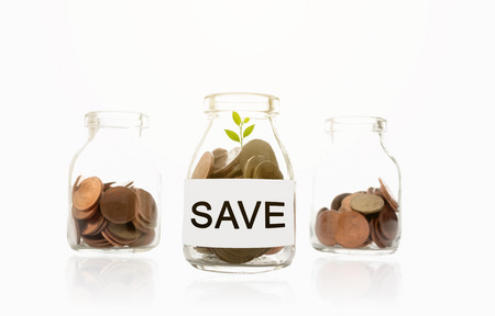 save message on glass bottles, plant and coins, investment and business conceptsの写真素材