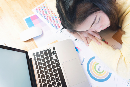 business woman tired asleep on the office room while working.の写真素材