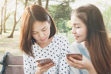 Woman listening to music in the park from the phone. And friends living together, a lifestyle in their holiday.の写真素材