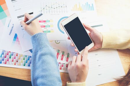 woman hand working with phone on wooden desk in office. can be used on advertising