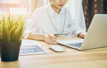 Young women are shopping online on laptop in my home. By credit card payment. Modern technology concept makes life easy, vintage effect.の写真素材