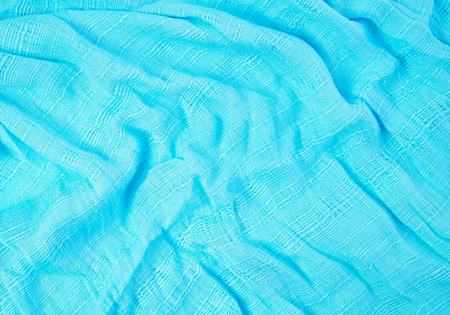 The fabric of the blue scarf. The show is a wave of light and shadow. For to be the background.の写真素材