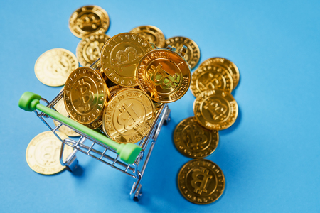 Gold Bitcoin placed in a small shopping cart. Digital currency concepts can be used to make online purchases.の写真素材
