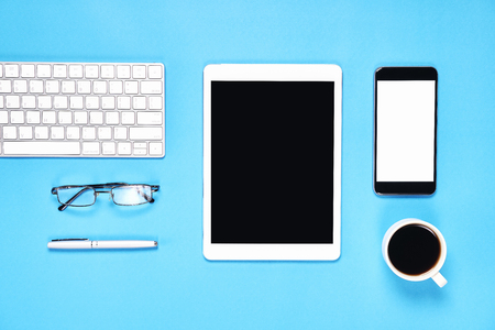 Top view, Modern workplace with tablet with smart phone placed on a pastel blue background. Copy space suitable for use in graphics.の写真素材