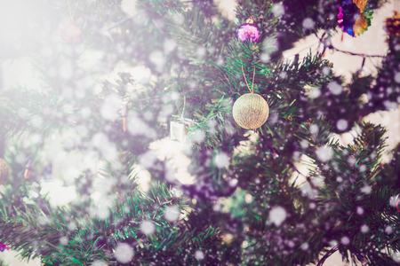 Close up Merry Christmas and Happy New Year on close up of decorated tree with snow bokeh background.の写真素材