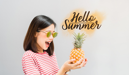 Young girl happy smile and cheerful in red dress and hold pineapple in hand, And have a message Hello Summer. Concept summer travel.の写真素材