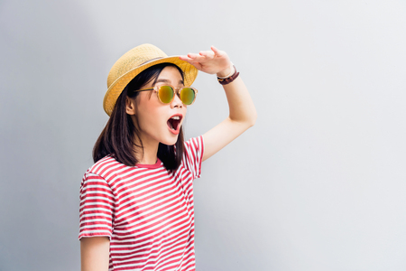 Young girl happy is Looking forward to finding something. Wear sunglasses with a reflection of the light sunshine. Concept summer travel.の写真素材