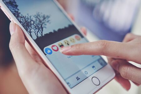 Bangkok, Thailand - January 7, 2018 : hand is pressing the Facebook screen on apple iphone 6 ,Social...
