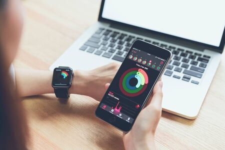 Bangkok, Thailand - April 09, 2018 : Women using the phone and checking activity app on Apple Watch, Created and developed by the Apple inc.のeditorial素材