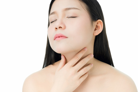 women hands are touching the neck because there is a red rash around the neck, a gray background gives soft light.の写真素材