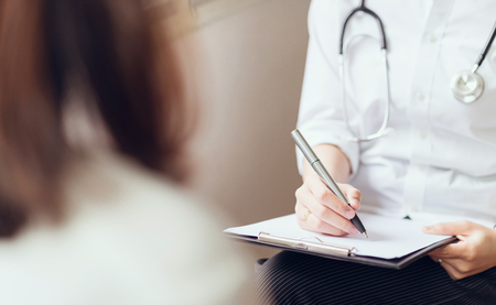 The doctor provides consultation with the patient and records the treatment history thoroughly. healthcare and professionalism concept.の写真素材