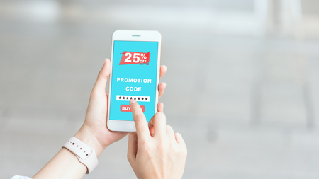 Women holding the smartphone to enter the code to get a discount from the store. The concept of providing marketing services on the internet for easy access to information.の写真素材