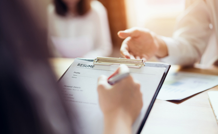 Young woman submit resume to employer to review job application. The concept presents the ability for the company to agree with the position of the job.の写真素材