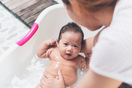 Mother bathing baby and children are happy and be smile.