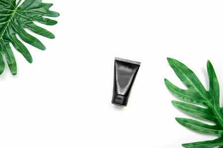 Mockup of cosmetic cream bottle, Blank label package and ingredients on a green leaves background. Concept of natural beauty products.の写真素材