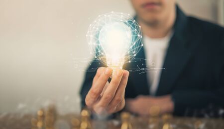 Hand holding light bulb with innovative and creativity are keys to success. Concept knowledge leads to ideas and inspiration.の写真素材