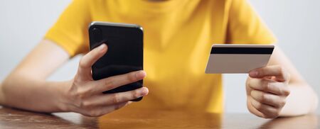 woman holding smart phone and credit card with shopping online. proportion of the banner for ads.