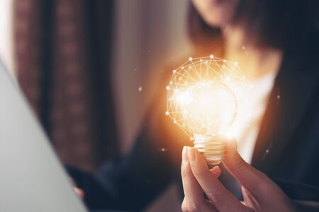Hand holding light bulb with innovative and creativity are keys to success. Concept knowledge leads...