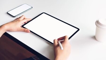 Woman using tablet screen blank and smartphone on the table mock up to promote your products. Concept of future and trend internet for easy access to information.の写真素材