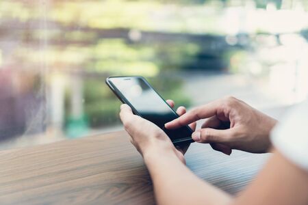 Man hand using black smartphone blank screen on isolated. Take your screen to put on advertising.の写真素材