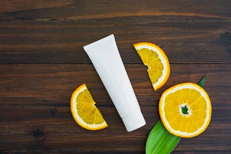 White vitamin c bottle and oil made from orange fruit extract, mockup of beauty product brand. Top view on the wood background.の写真素材