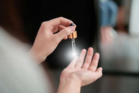 Woman holding a product Serum bottle for spa products and make up. The skin is smooth and beautiful.の写真素材