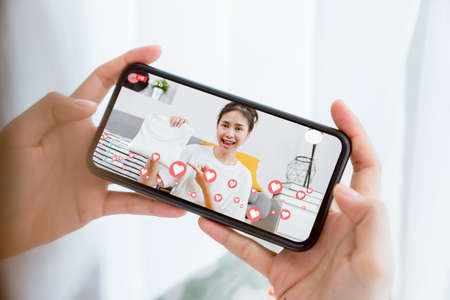 Young Asian women showing clothes and sale online on social with smartphone to customers from home. Network technology concept.の写真素材
