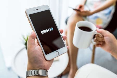 Bangkok, Thailand - September 5, 2020 : Hand holding smartphone with show HBO application. streaming service for watching premium TV episodes and movies.のeditorial素材