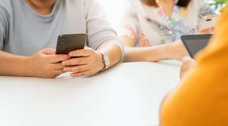 Group friends using smartphone, During leisure time. The concept of using the phone is essential in everyday life.の写真素材