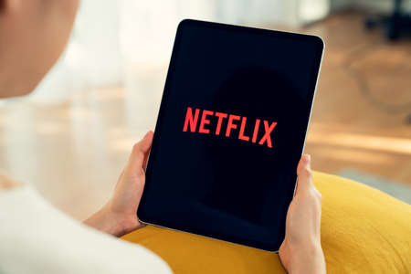 Bangkok, Thailand - September 5, 2020 : women use Netflix app on apple iPhone X screen. Netflix is an international leading subscription service for watching TV episodes and movies.のeditorial素材