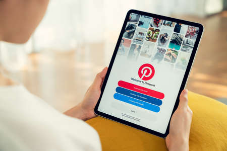 Bangkok, Thailand - September 5 2020 : Woman hand is pressing the Facebook screen on apple iphone 11, Social media are using for information sharing and networking.のeditorial素材