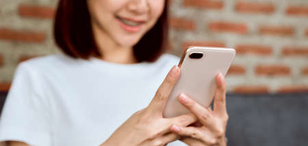 Close-up of woman holding a smartphone and using online social on lifestyle. Technology for communication concept.の写真素材