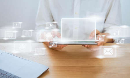Concept technology internet and networking, businessman hand holding tablet with media icon on...