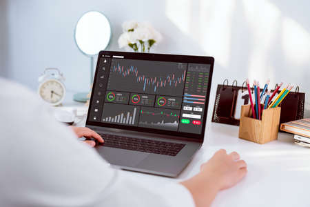 Stock exchange market concept, businesswoman trader looking computer with graphs analysis candle line on table in office, diagrams on screen.の写真素材