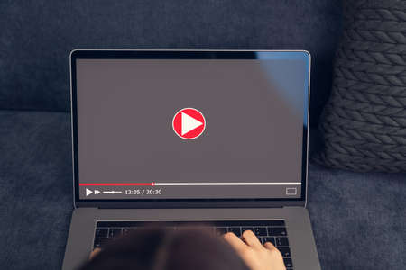 Woman watching video online on laptop.